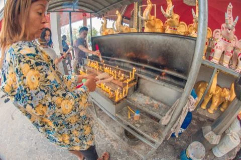 Buddhist devotee lighting a stick with a candle at Hat Yai Municipal Park. Stock Photos