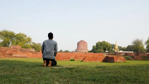 Buddhist devotee offering sacred worships to dhamek stupa ruins at day video is Stock Footage 316038138