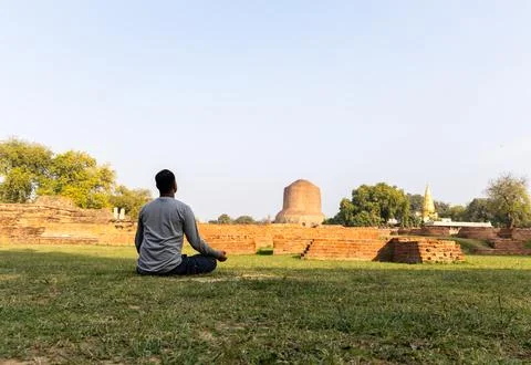 Buddhist devotee performing sacred meditation at dhamek stupa ruins in day .. 写真素材