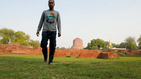 Buddhist devotee walking out after performing sacred prayer at dhamek stupa Stock Footage 316037875