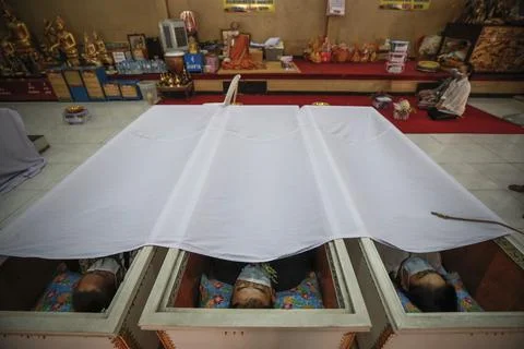 Buddhist devotees lie inside coffins for good karma, Bangkok, Thailand - 13 Feb  Stock Photos