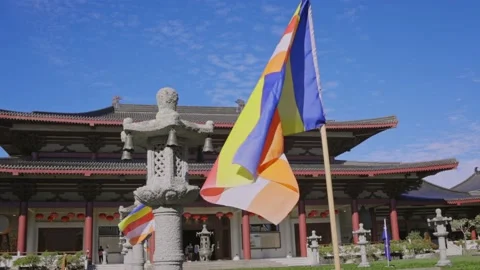 Buddhist flag waving in the wind with temple in the background Video stock 152501635