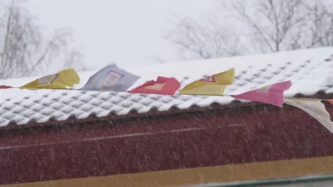Buddhist Flags Waving in Snowfall and Temple Roof Background, Close Up Stock Footage 230911435