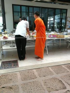 Buddhist give the offering dedicated essentials and food to the monks at Thai Stock Photos