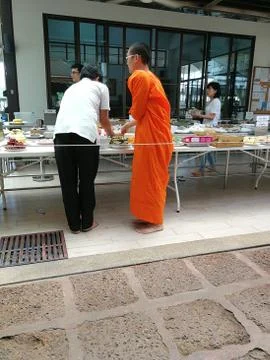 Buddhist give the offering dedicated essentials and food to the monks at Thai Stock Photos