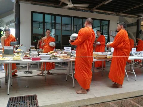 Buddhist give the offering dedicated essentials and food to the monks at Thai Stock Photos