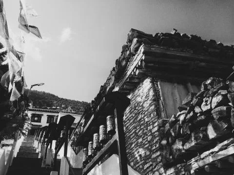 Buddhist monastery building with prayer flags and wheels Stock Photos