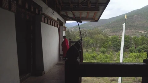 A Buddhist monk adjusting his robe at a balcony of an old majestic monastery Video stock 104966074