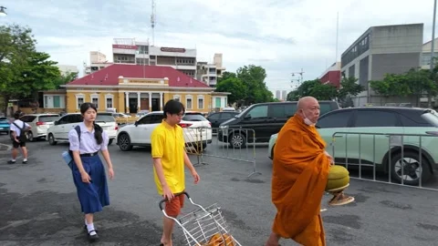 Buddhist Monk and Students Walking Past Fruit Cart in Bangkok Stock Footage 339411170