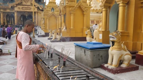 Buddhist monk boy lighting candle at Shwedagon pagoda. Stock Footage 110047732