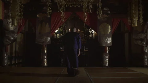 Buddhist monk kneeling and praying in a traditional japanese temple Stock Footage 340562602