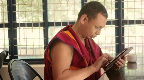 Buddhist Monk librarian working on tablet Stock Footage 60206696