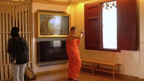 Buddhist Monk in Orange Robe Taking Pictures With Digital Camera at Thai Temple Stock Footage 122147980