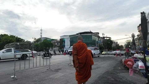 Buddhist Monk in Orange Robe Walking Through Busy Bangkok Street Stock Footage 339405071
