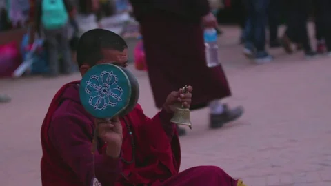 Buddhist monk ringing the prayer bells in street Stock Footage 77453475