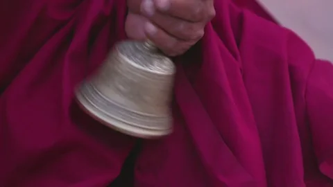 Buddhist monk ringing the prayer bells in street Stock Footage 77453667