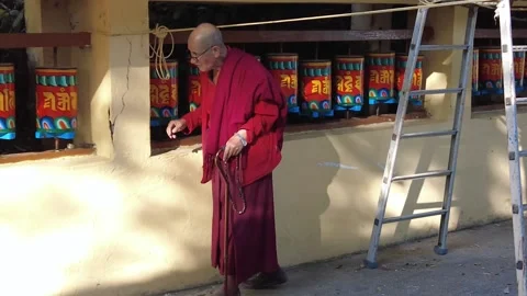 Buddhist monk rolling prayer wheels around Namgyal Monastery Stock Footage 228822173
