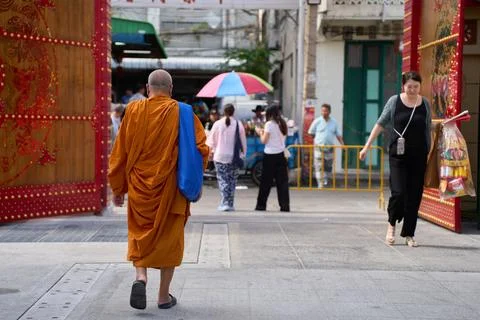 A Buddhist monk standing at the exit of Wat Mangkon Kamalawat, Bangkok, Thailand Photos