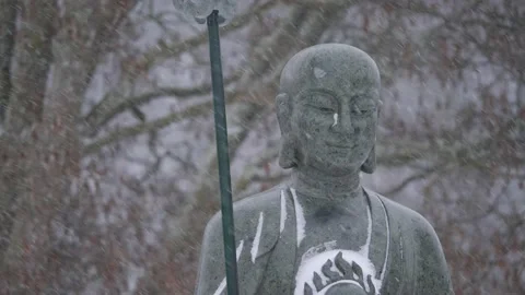 Buddhist Monk Statue in Heavy Snowfall, Buddhism in Winter Season, Medium shot Stock Footage 231324289