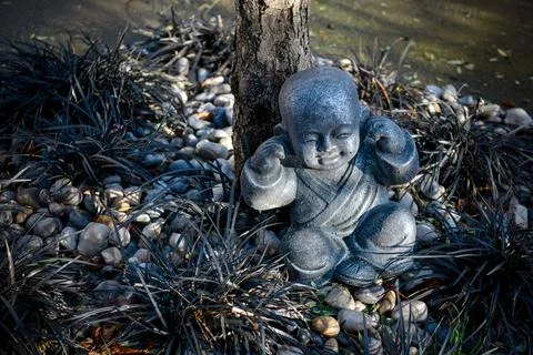 Buddhist monk statue using hand action to close the ears Stock Photos