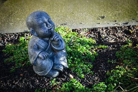 Buddhist monk statue using hand action to close the mouth Stock Photos