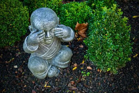 Buddhist monk statue using hand action to close the eyes Stock Photos