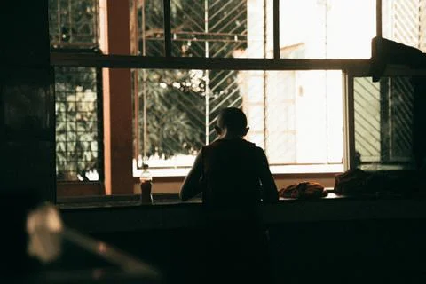 Buddhist monk staying by window Stock Photos