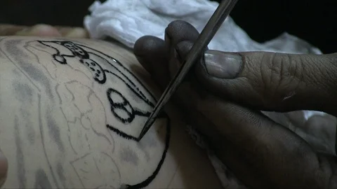 Buddhist monk tattooing a man Stock Footage 103450992