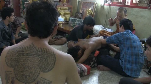 Buddhist monk tattooing a man Stock Footage 103451030