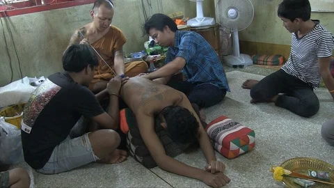Buddhist monk tattooing a man Stock Footage 103451052
