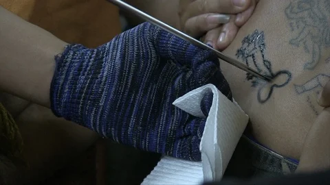 Buddhist monk tattooing a man Stock Footage 103451118