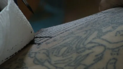 Buddhist monk tattooing a man Stock Footage 103451209