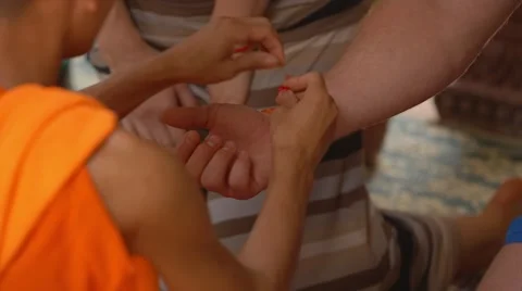 Buddhist monk ties the amulet on man's hand, ritual Stock Footage 49403537