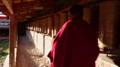 A Buddhist monk turning the prayer wheels, Eastern Tibet, China Video stock 100074208