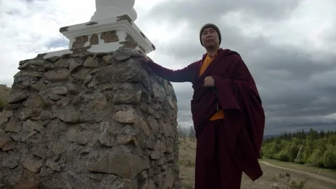 Buddhist monk walking around buddhist stupa Stock Footage 132518396