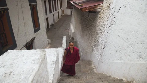 A buddhist monk walking inside Punakha Dzong in Bhutan Stock Footage 104957887