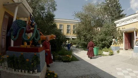 Buddhist monks ancient statues and cleaners in the courtyard in Mongolian datsan Stock Footage 81816385