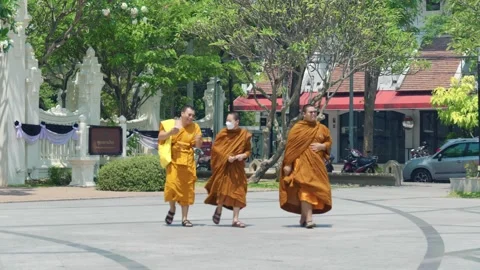 Buddhist monks in saffron robes walking across temple plaza in Chiang Mai Stock Footage 345454462