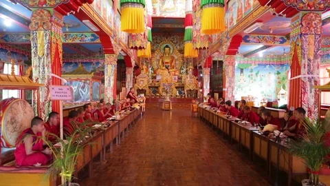 Buddhist monks sitting in front of a Buddha's statue in a temple Stock Footage 77443655