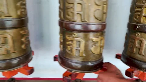 Buddhist prayer drum rollers red golden color man rotating in Tibetan Monastery Video stock 257244783