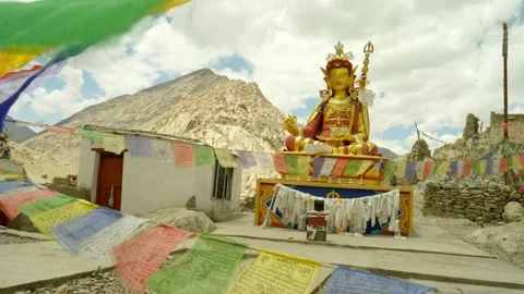 Buddhist prayer flags in front of golden Buddha statue Stock Footage 282526125