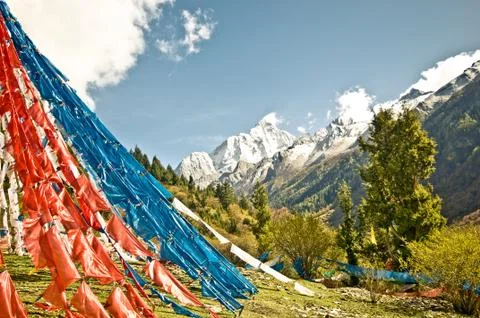 Buddhist prayer flags in front of snowy mountains in Higlands o China Stock Photos