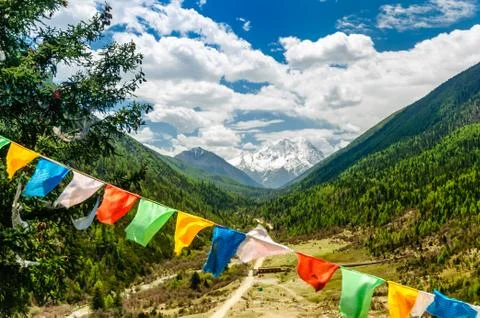 Buddhist prayer flags before Mount Yala in Sichuan Province - China Stock Photos