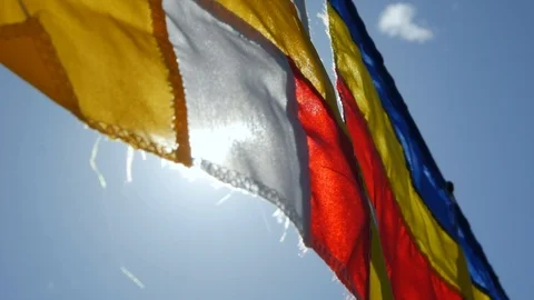 Buddhist prayer flags swaying in the wind in the rays of the rising sun in a Stock Footage 114427097