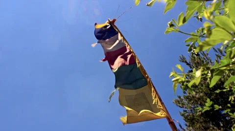 Buddhist prayer flags wave in the wind against a clear blue sky. Slow motion. Stock Footage 39833306