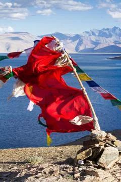 Buddhist prayer flags on the wind against the blue lake, mountains and sky Stockfoto's