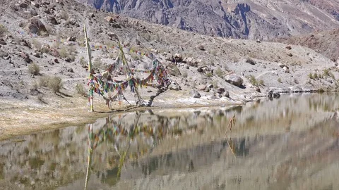 Buddhist praying flags blow in wind. Tso Yarab sacred lake, India, Zoom Stock Footage 112803927