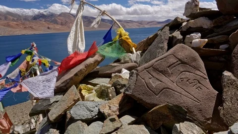 Buddhist praying flags fluttering against Tso Moriri lake and Himalaya mountains Stock Footage 93855108