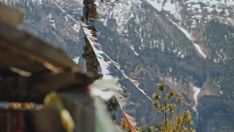 Buddhist ragged prayer flags hang in mountains, flutters, sways in wind, Nepal Stock Footage 124677469