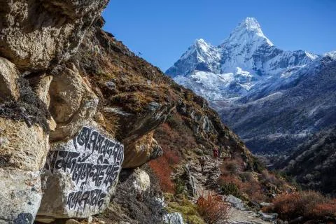 Buddhist script below the peak of Ama Dablam on the trail to Everest. Stock Photos